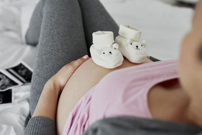 Midsection of woman with toy sitting at home