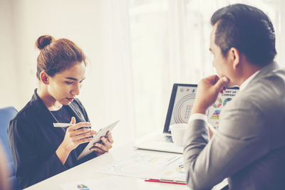 Business people discussing while sitting at desk in office