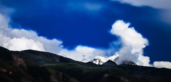 Scenic view of mountains against cloudy sky