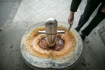 Low section of man standing by drinking fountain