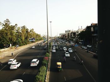 Traffic on road in city against clear sky