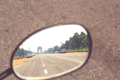 Road seen through side-view mirror of car