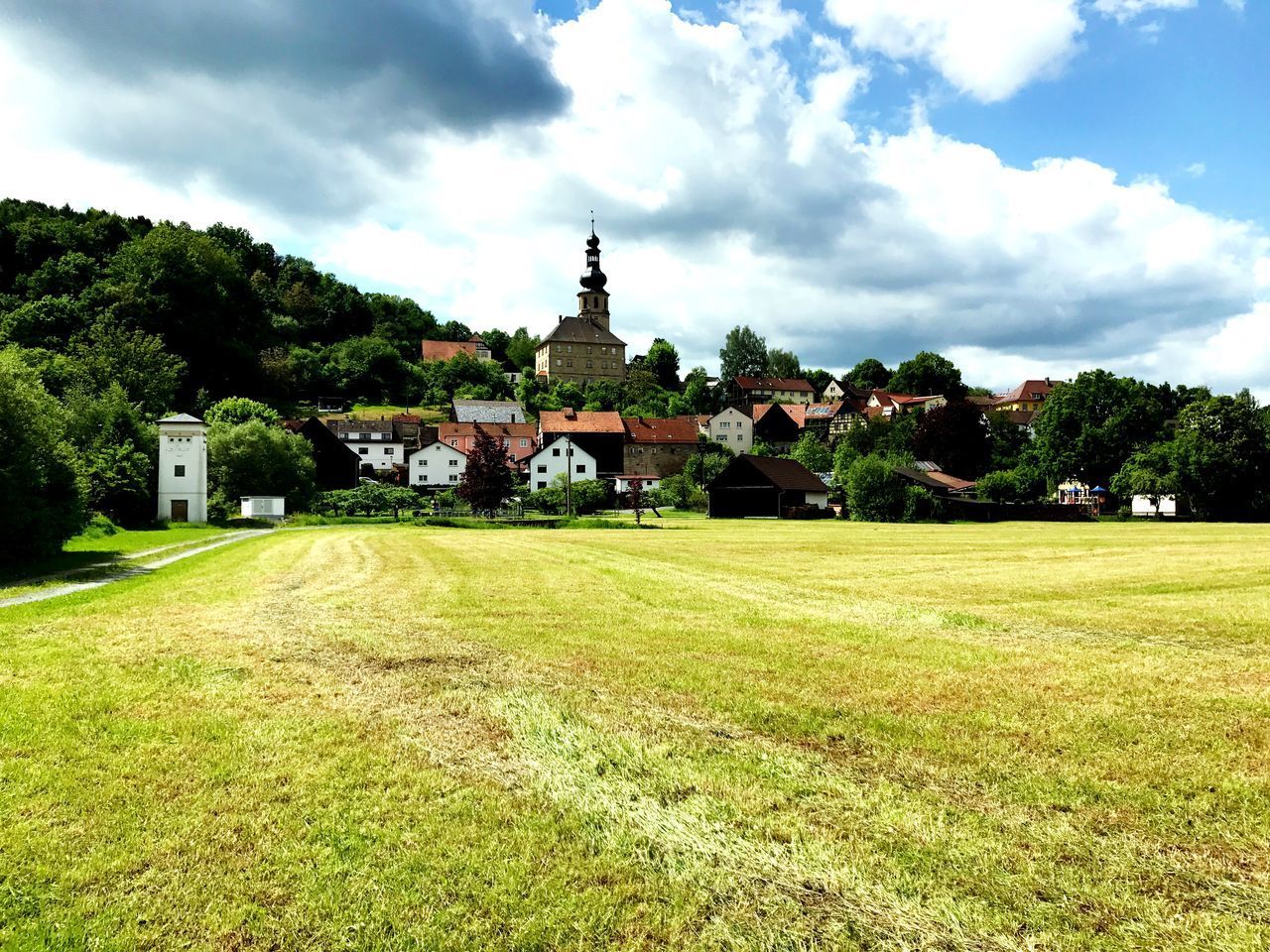 BUILT STRUCTURE BY TREES AND BUILDINGS AGAINST SKY