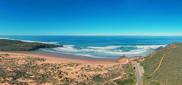 Panoramic view of beach against clear blue sky