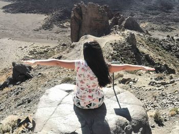 Rear view of woman standing on rock