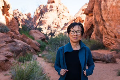 Portrait of smiling woman standing on rock formation