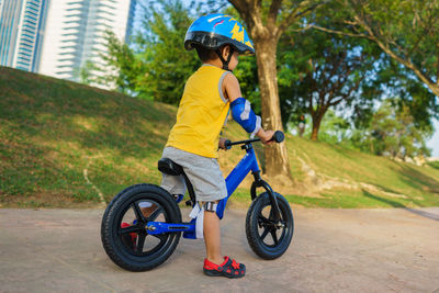 Full length of boy riding bicycle on road