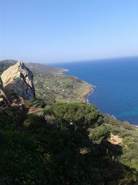 Scenic view of sea and mountains against clear blue sky