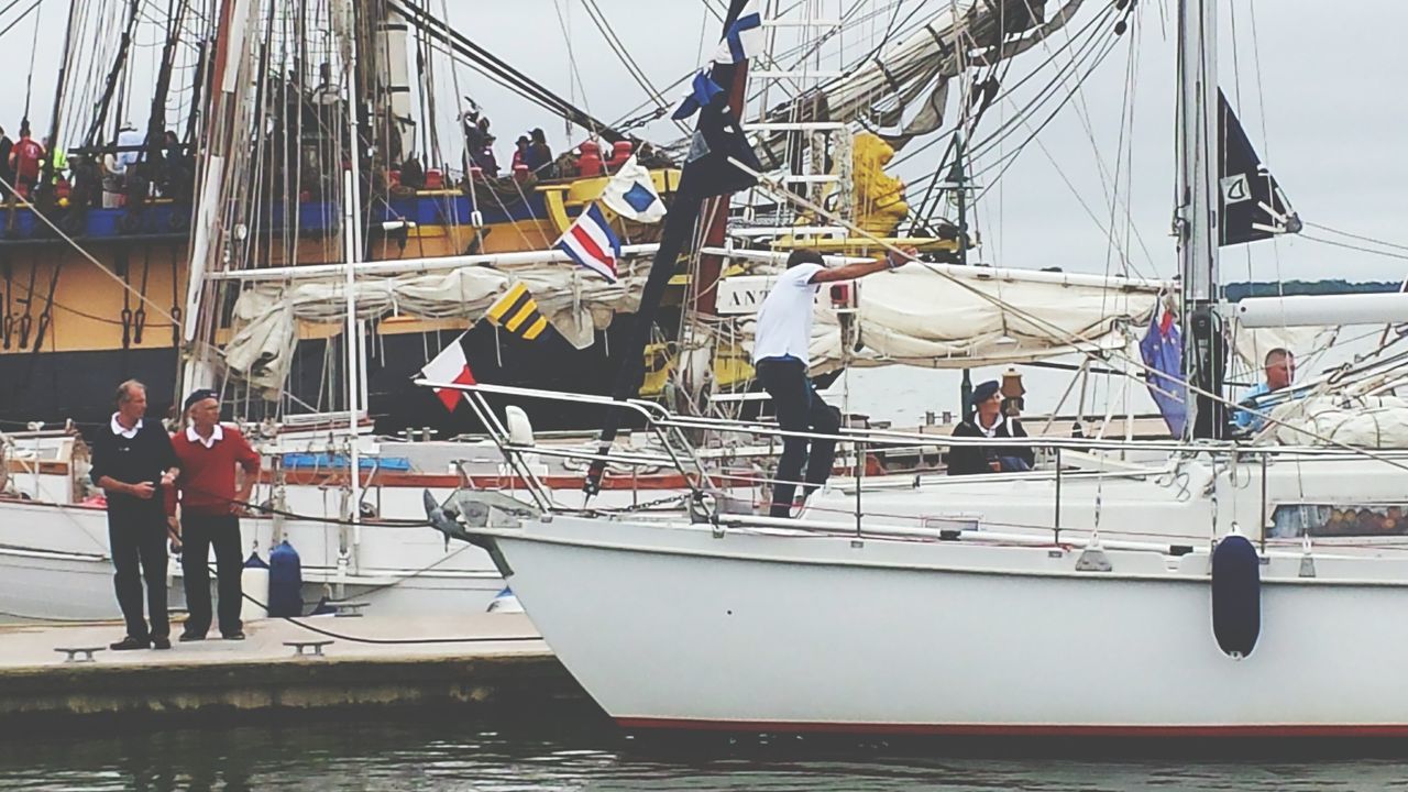 men, transportation, nautical vessel, lifestyles, mode of transport, leisure activity, water, person, mast, full length, medium group of people, sky, built structure, boat, rope, day, travel, architecture, large group of people