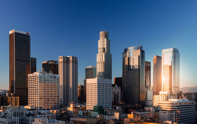 Skyscrapers in city against clear blue sky