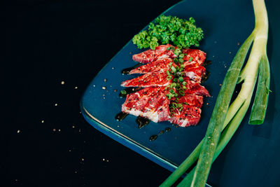 High angle view of meat and salad in tray on table