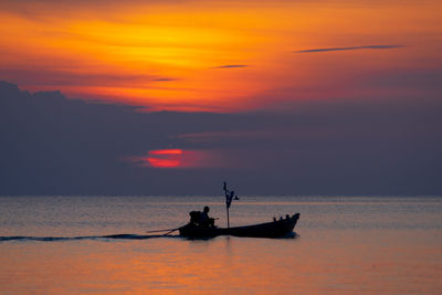 Silhouette boat in sea against sky during sunset