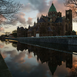 Cathedral of saint bavo reflecting in river during sunset