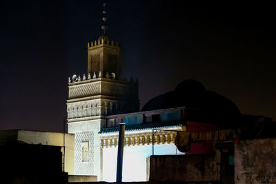 Low angle view of illuminated buildings against sky at night