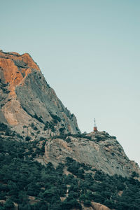 Lighthouse on mountain against clear sky