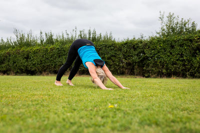 Rear view of man with arms raised against sky