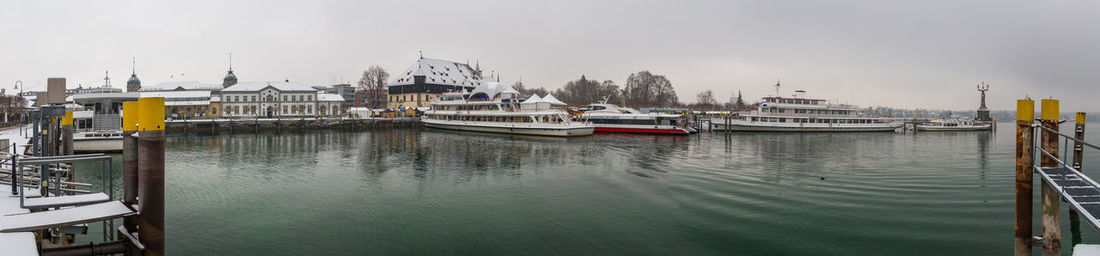 Boats moored in harbor against sky