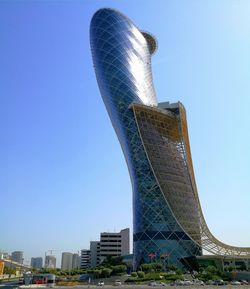 Low angle view of skyscrapers against blue sky