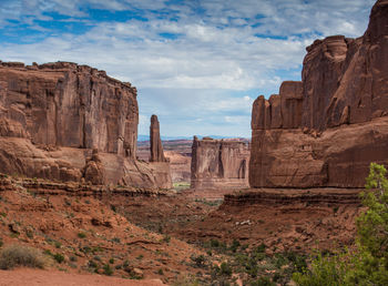 Rock formations on landscape against cloudy sky