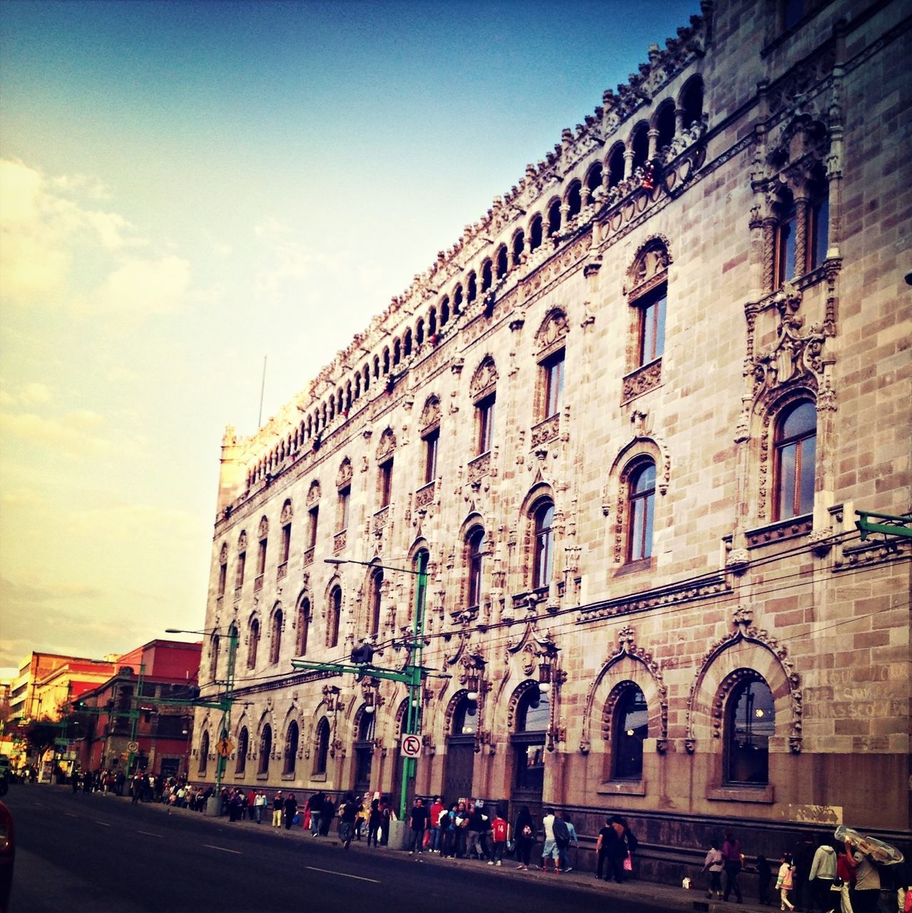 architecture, built structure, building exterior, arch, history, street, sky, transportation, travel destinations, window, incidental people, travel, large group of people, tourism, city, road, person, car, old town