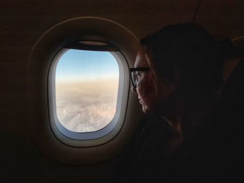 Woman looking through airplane window