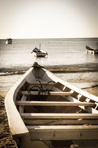 Boats in sea against clear sky