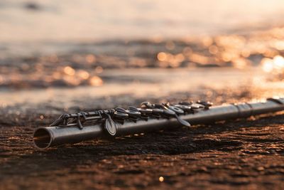 Close-up of chain on land against sky during sunset