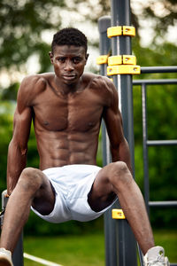 Shirtless young man exercising in gym