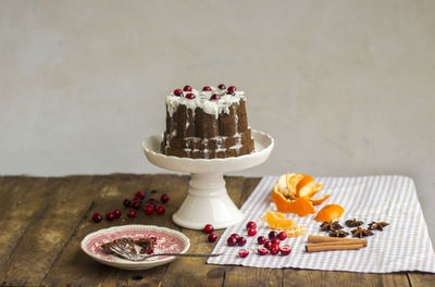 Cake with cranberries on stand over table