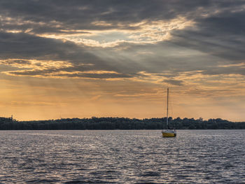 Rays of light on the cospudener see with sailboat