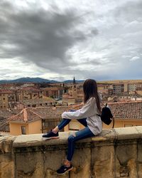Woman sitting against townscape