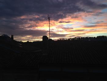 Silhouette of built structures against dramatic sky