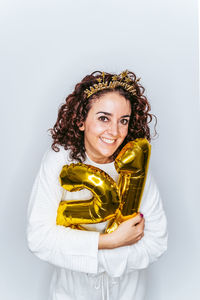 Portrait smiling woman wearing hat holding balloons against white backgrounds