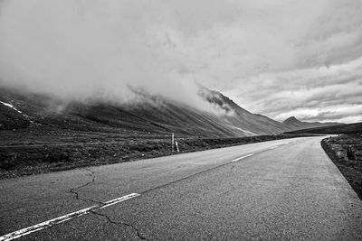 Empty road by mountain against sky