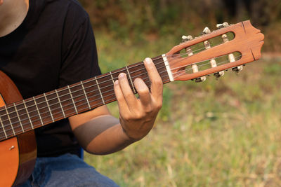 Midsection of man playing guitar