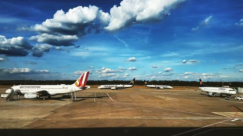 Airplane flying over airport runway against sky