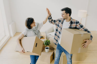Couple holding boxes on home