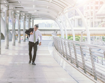 Mid adult businessman walking on elevated walkway