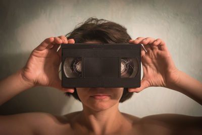 Portrait of shirtless man photographing