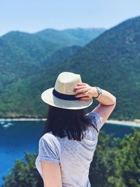 Rear view of woman wearing hat against mountains