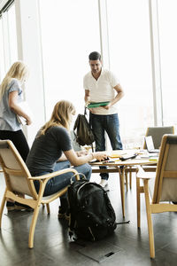 Young friends studying at desk in university library