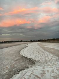 Scenic view of snowy field against sky during sunset