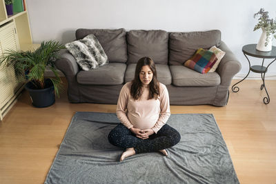 High angle view of woman sitting on sofa at home