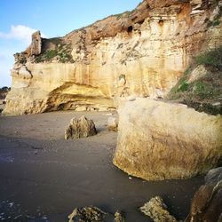 Rock formations by sea against sky