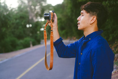 Side view of young man photographing