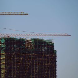 Low angle view of crane against clear sky