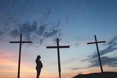 Silhouette cross against sky during sunset