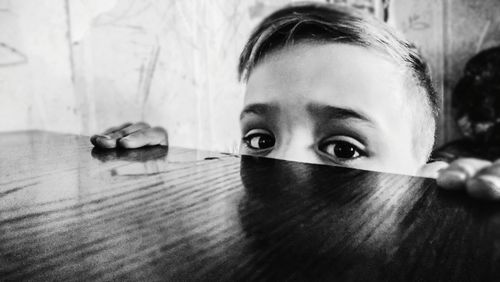 Close-up portrait of girl holding table