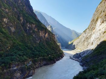 Scenic view of river amidst mountains against clear sky