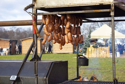 Delicious hot sausages cooked in a metal street oven hang at the food market.